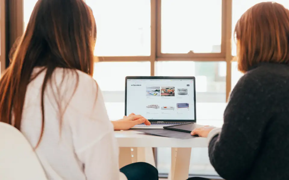 Deux collègues consultant le blog d’une entreprise sur un ordinateur portable
