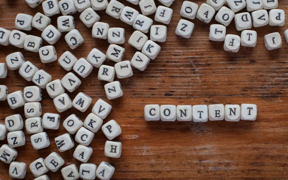 Lettres en bois formant le mot CONTENT : mettre en place une stratégie de contenu