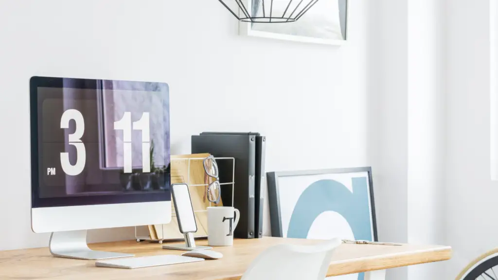 Bureau lumineux avec ordinateur et horloge : planifier sa stratégie de content marketing