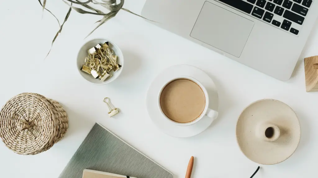 Bureau vu de dessus avec ordinateur portable, café et carnet : préparer sa stratégie de content marketing