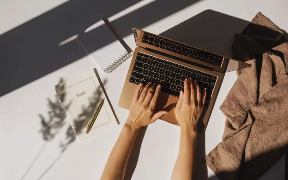 Mains tapant sur un ordinateur portable, pour illustrer le pull et le push content